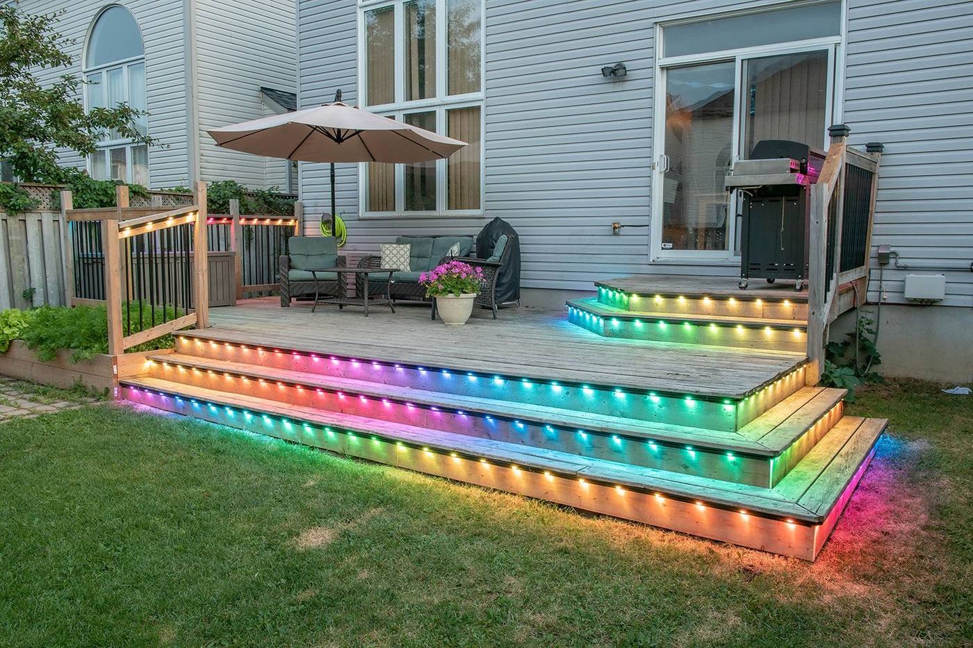 A rainbow-lit backyard deck set up for a gathering