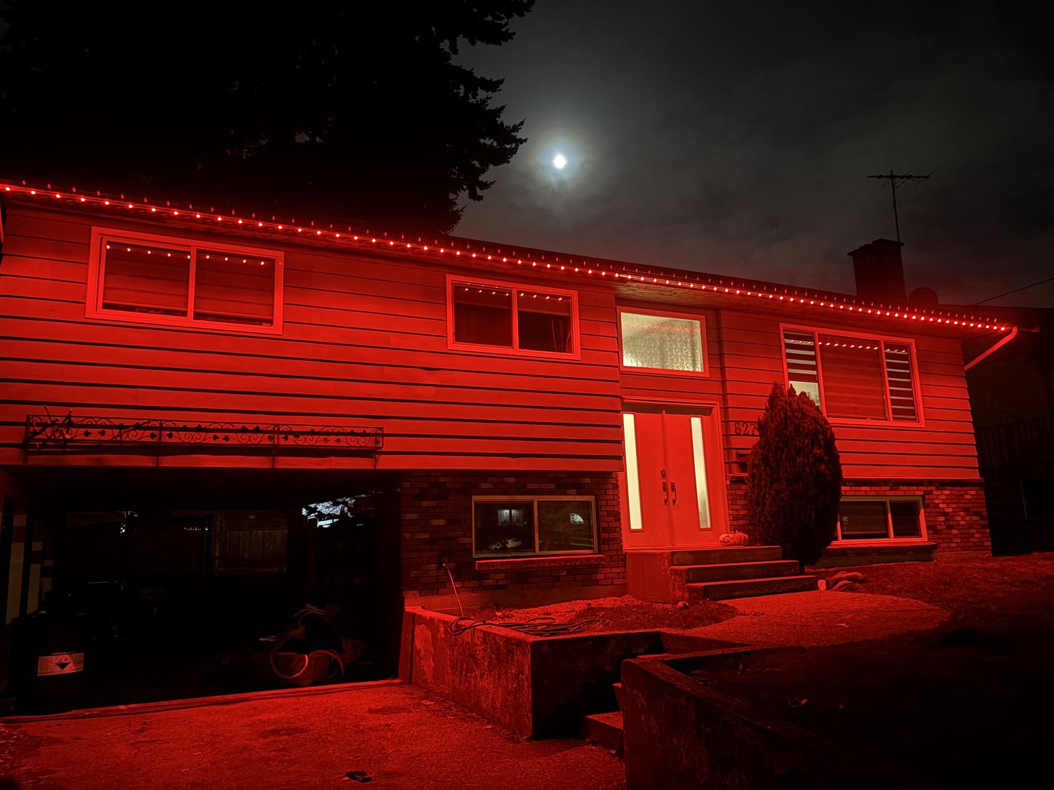 A real Delta Exterior customer home lit entirely in red permanent LED lighting under a full moon